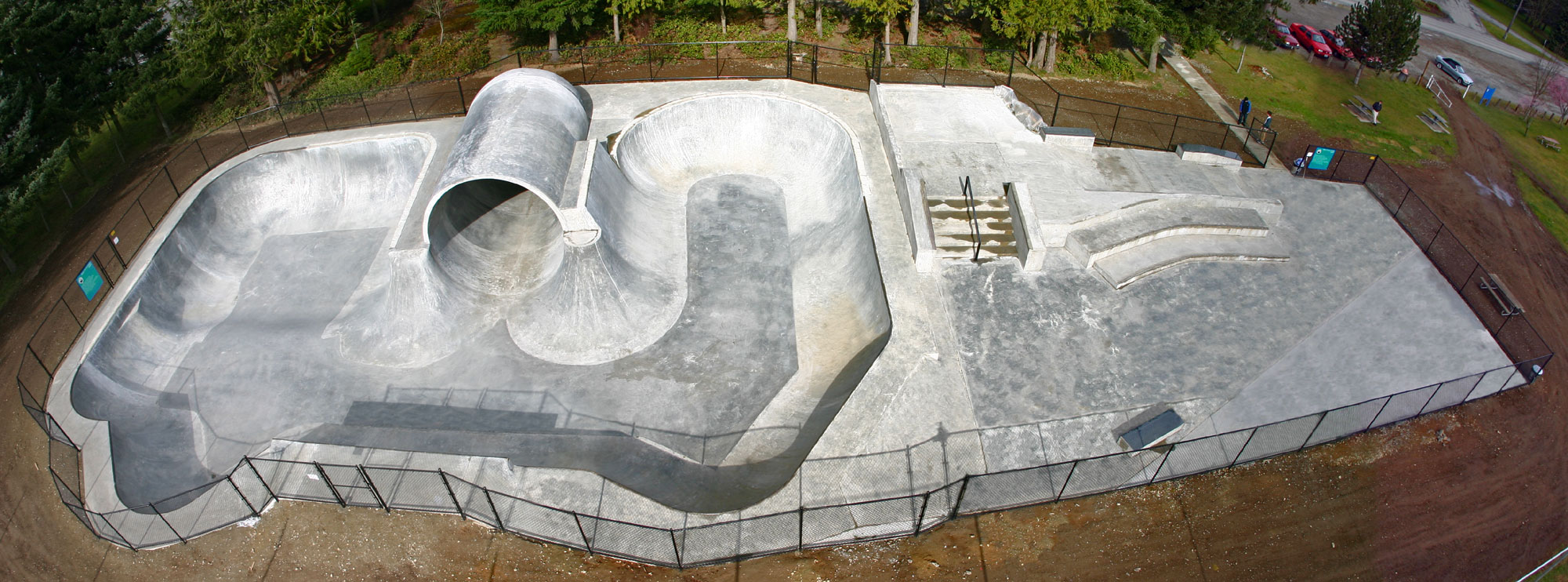 Arlington Skatepark from the air, the full pipe and bowl in the near corner and the street section stretching away behind it.