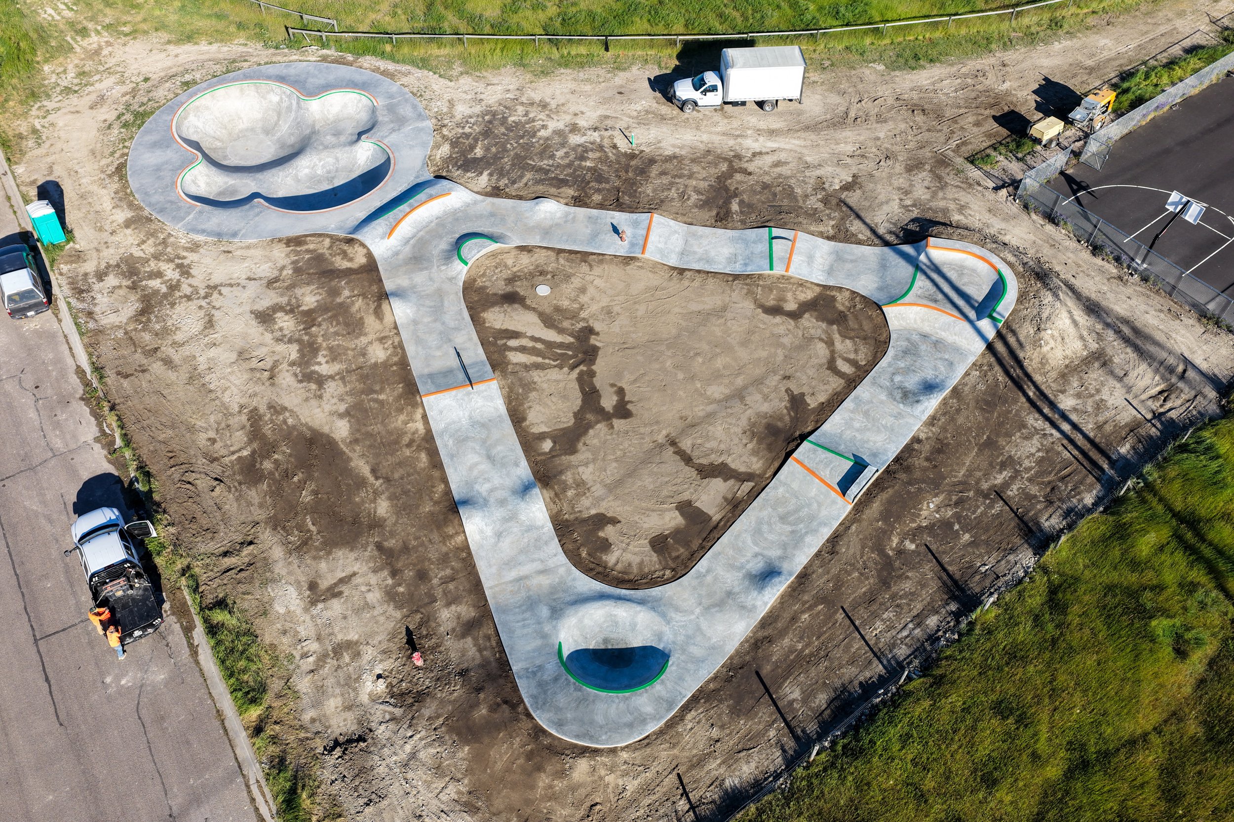 Drone shot of the Elmo park: a clover bowl at one end and a loop of flow terrain wrapped around a dirt infield.