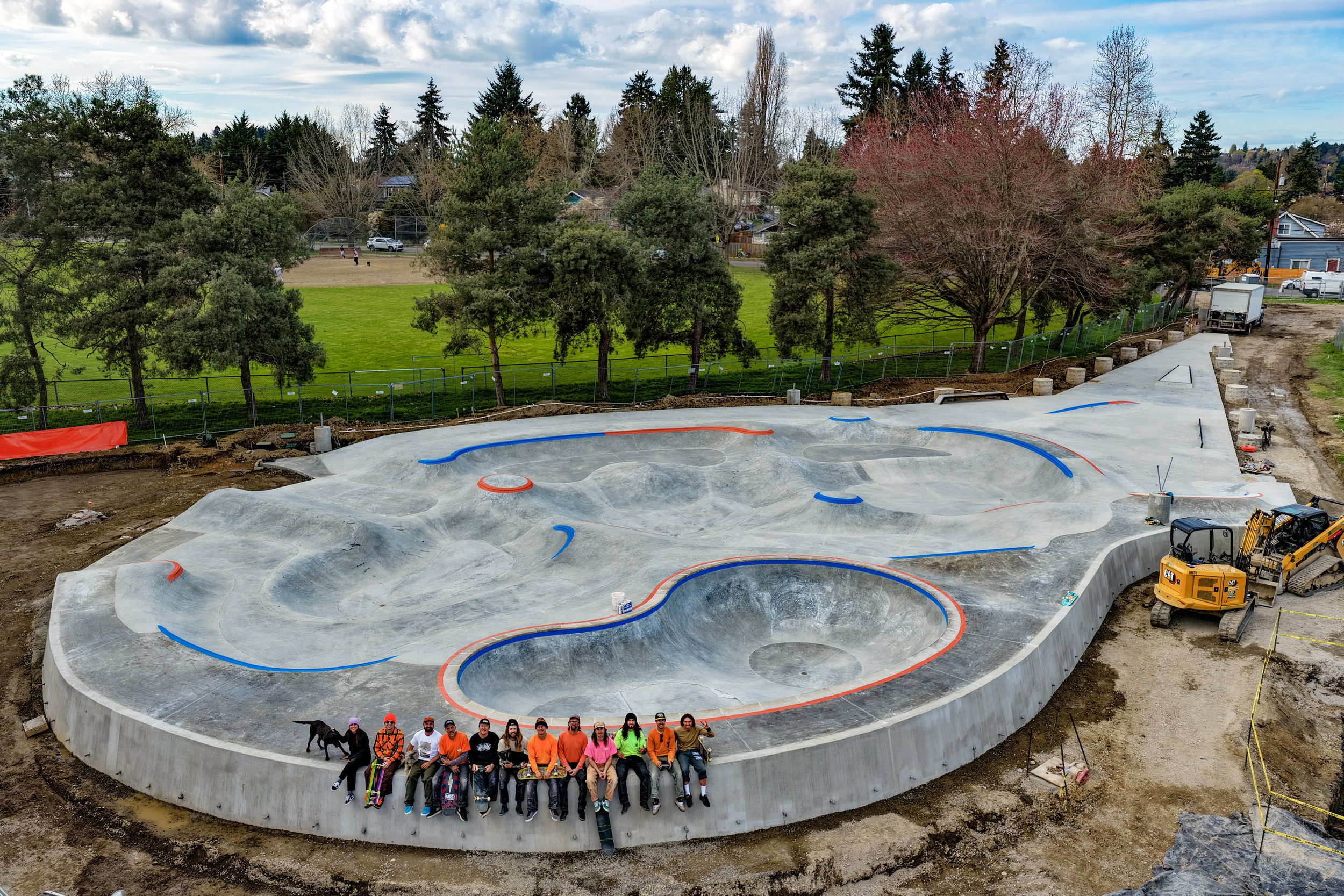 The Rainier Beach crew lined up along the deck of the new park, the big bowl with its red and blue coping in front of them.