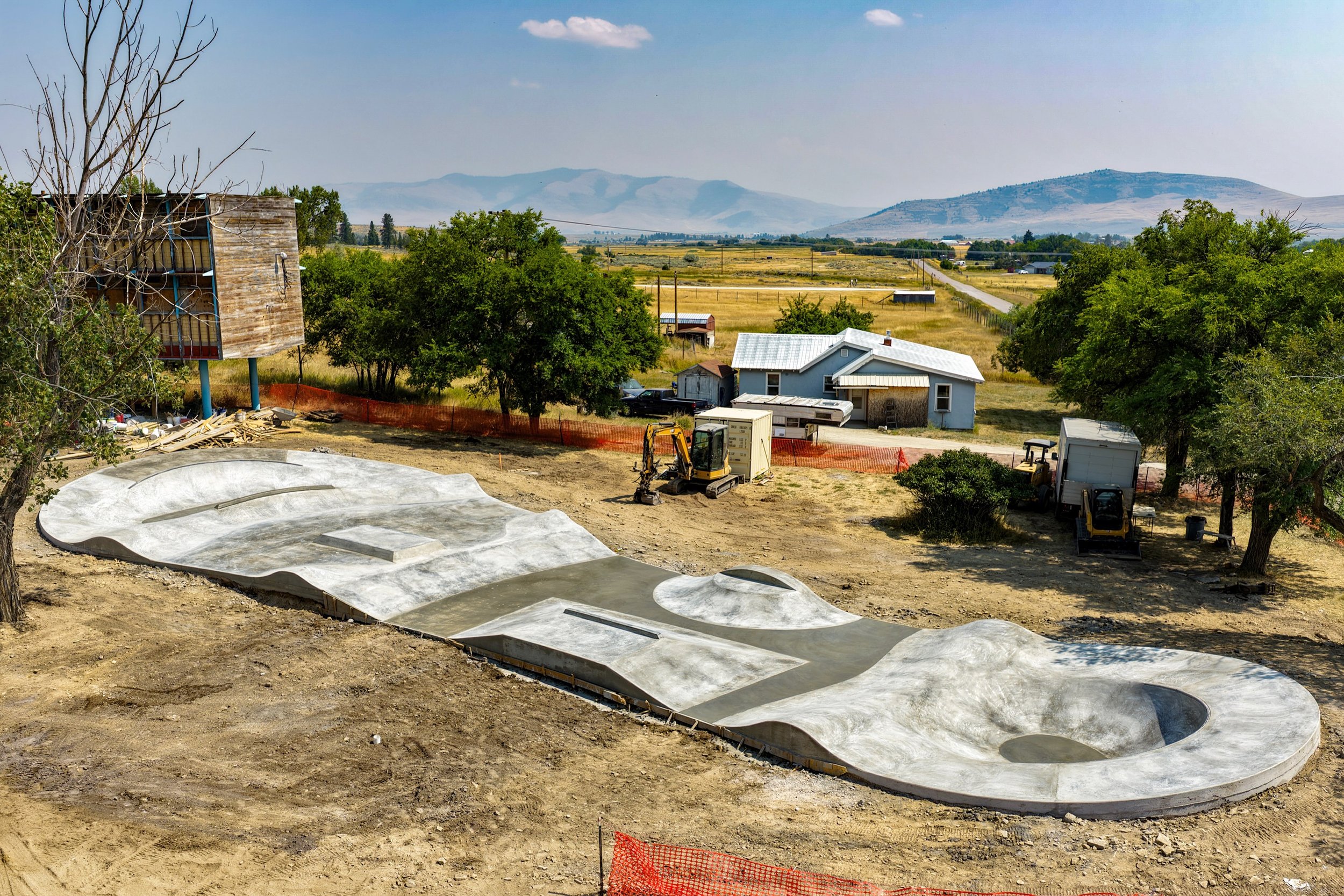 The finished Hot Springs pour from above: banks, hips and a ledge running into a round bowl, with the mountains of western Montana behind.