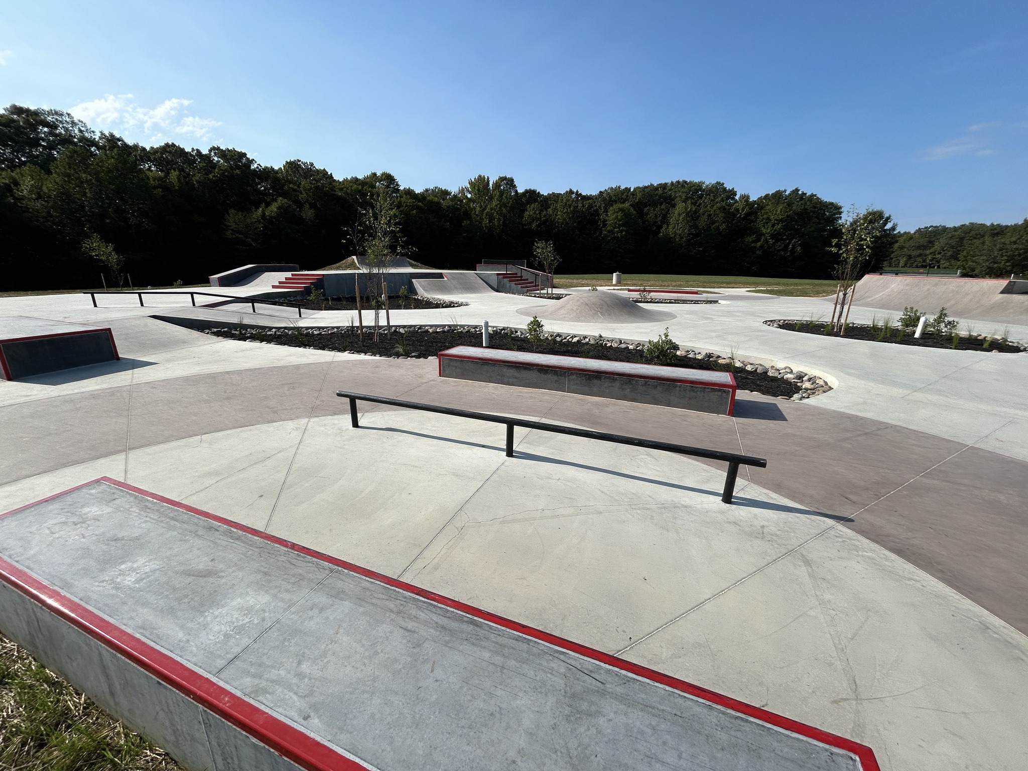 The new Chaptico street course, its ledges and flat bar trimmed in red, with the woods of Chaptico Park behind.